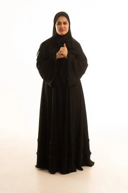 امرأة سعودية بالعباءة السوداء بتعبير وجه قلق