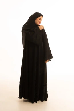 امرأة سعودية بالعباءة السوداء التقليدية بخلفية بيضاء