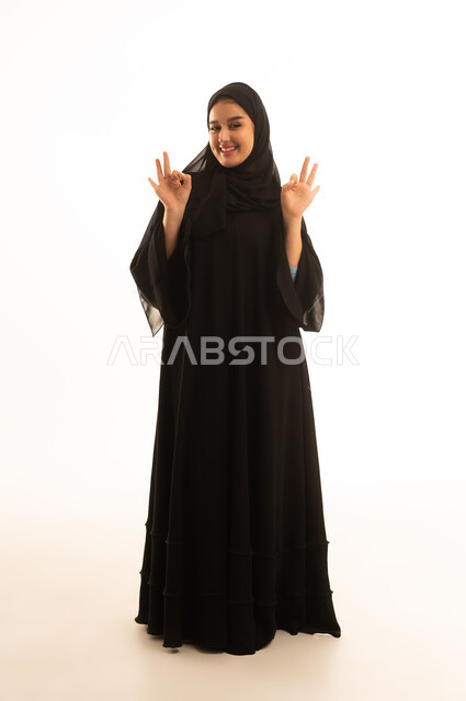 امرأة سعودية بالعباءة السوداء تقوم بإيماءة الموافقة