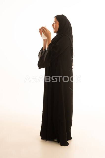 Saudi Woman Sneezing with Tissue in Black Abaya