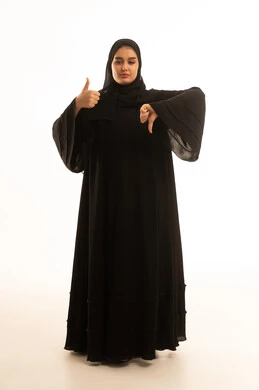 امرأة سعودية بالعباءة تشير بالإعجاب وعدم الإعجاب