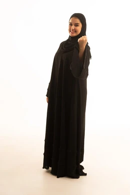 امرأة سعودية بالعباءة السوداء تحتفل بإيماءة النصر