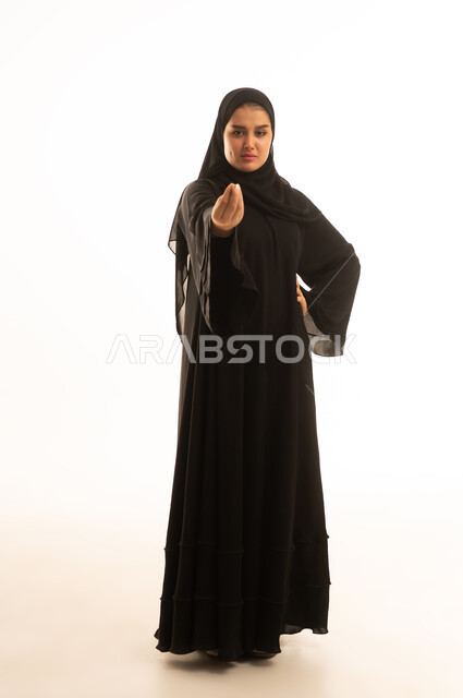 امرأة سعودية بالعباءة السوداء تقوم بإيماءة غاضبة