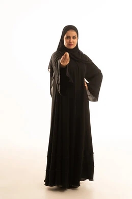 امرأة سعودية بالعباءة السوداء تقوم بإيماءة غاضبة