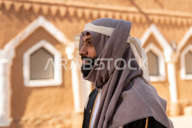 صورة من الجانب رجل عربي سعودي خليجي يرتدي زي يوم التأسيسي ملامح الرجولة والأصالة، ذكرى تأسيس الدوله السعوديه الاولى على يد الامام محمد بن سعود, يوم بدينا 22 فبراير 1727م, العمق التاريخي والحضاري للمملكة،الإحتفالات الوطنيه في المنطقه الوسطى