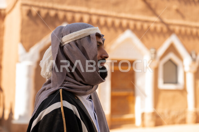 صورة من الجانب رجل عربي سعودي خليجي يرتدي زي يوم التأسيسي ملامح الرجولة والأصالة، ذكرى تأسيس الدوله السعوديه الاولى على يد الامام محمد بن سعود, يوم بدينا 22 فبراير 1727م, العمق التاريخي والحضاري للمملكة،الإحتفالات الوطنيه في المنطقه الوسطى