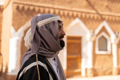 A side image of an Arab Saudi Gulf man wearing the attire of the Foundation Day, showcasing features of masculinity and authenticity, commemorating the establishment of the first Saudi state by Imam Muhammad bin Saud, which began on February 22, 1727. The historical and cultural depth of the Kingdom, national celebrations in the central region.