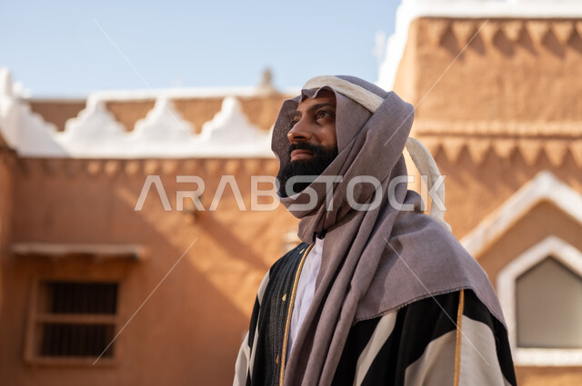 صورة من الجانب رجل عربي سعودي خليجي يرتدي زي يوم التأسيسي ملامح الرجولة والأصالة، ذكرى تأسيس الدوله السعوديه الاولى على يد الامام محمد بن سعود, يوم بدينا 22 فبراير 1727م, العمق التاريخي والحضاري للمملكة،الإحتفالات الوطنيه في المنطقه الوسطى