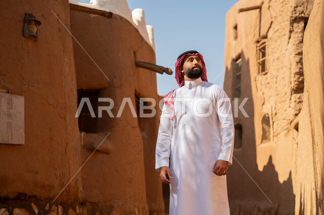 رجل عربي سعودي خليجي يرتدي الزي التقليدي ثوب أبيض وشماخ النظرلشيء ما في الاعلى، ذكرى تأسيس الدوله السعوديه الاولى على يد الامام محمد بن سعود, يوم بدينا 22 فبراير 1727م, العمق التاريخي والحضاري للمملكة،الإحتفالات الوطنيه في المنطقه الوسطى
