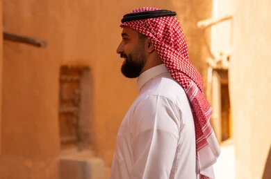 صورة من الجانب لرجل عربي سعودي خليجي يرتدي الزي التقليدي ثوب أبيض وشماخ الوقوف بثقة بالنفس، ذكرى تأسيس الدوله السعوديه الاولى على يد الامام محمد بن سعود, يوم بدينا 22 فبراير 1727م, العمق التاريخي والحضاري للمملكة،الإحتفالات الوطنيه في المنطقه الوسطى