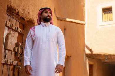 An Arab Saudi Gulf man wearing traditional attire, a white thobe and a shemagh, embodies masculinity and authenticity. It marks the anniversary of the establishment of the first Saudi state by Imam Muhammad bin Saud, which began on February 22, 1727. The historical and cultural depth of the Kingdom, national celebrations in the central region.