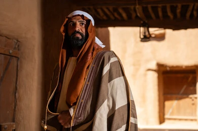 An Arab Saudi Gulf man wearing the founding day attire stands inside a mud building, commemorating the establishment of the first Saudi state by Imam Muhammad bin Saud, on the day we began, February 22, 1727. The historical and cultural depth of the Kingdom is the identity of Saudi National Day 92.