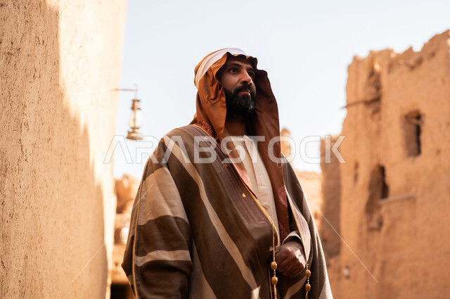 An Arab Saudi Gulf man wearing the founding day attire stands with pride and dignity in the history of the Kingdom, commemorating the establishment of the first Saudi state by Imam Muhammad bin Saud, on the day we began, February 22, 1727. The historical and civilizational depth of the Kingdom is the identity of Saudi National Day 92.