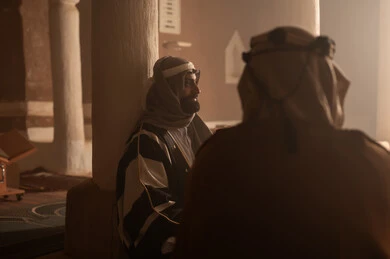 رجل كبير السن عربي سعودي خليجي يرتدي البشت وعقال يوم التأسيس يجلس مع رجل داخل مبنى طيني, ذكرى تأسيس الدوله السعوديه الاولى على يد الامام محمد بن سعود, يوم بدينا 22 فبراير 1727م, العمق التاريخي والحضاري للمملكة، ارتداء الأزياء التقليدية تعكس التراث