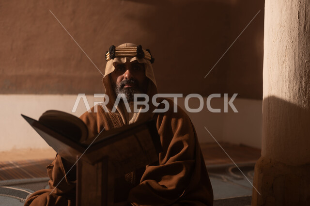 ارتداء الأزياء التقليدية تعكس التراث, رجل كبير السن عربي سعودي خليجي يرتدي البشت وعقال يوم التأسيس يقرأ القران الكريم, ذكرى تأسيس الدوله السعوديه الاولى على يد الامام محمد بن سعود, يوم بدينا 22 فبراير 1727م, العمق التاريخي والحضاري للمملكة