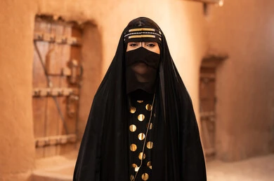 ارتداء الزي الشعبي في ذكرى تأسيس الدولة السعودية الاولى 22 فبراير، الفخر والاعتزاز بالهوية الوطنية، نمط حياة البدو الشعبية في البيوت الطينية التراثية، يوم بدينا 1727 م، امرأة عربية خليجية سعودية ترتدي العباءة السوداء والبرقع في منزل قديم