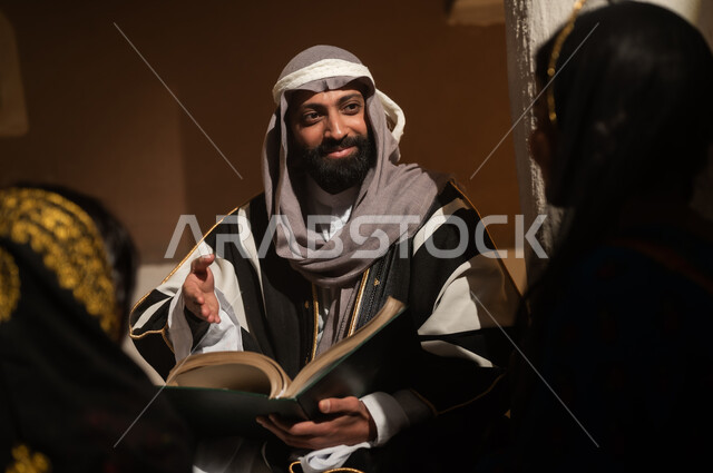 رواية قصة للابناء، الجلوس في احدى البيوت التراثية الطينية ،يوم بدينا 1727 م ، المحبة بين افراد الأسرة ،ذكرى تأسيس الدولة السعودية الأولى 22 فبراير ، رجل عربي خليجي سعودي يجلس مع أبنائه يرتدون الأزياء الشعبية في الأعياد الوطنية
