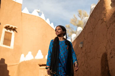 فتاة عربية خليجية سعودية ترتدي الزي التراثي تقف امام باب خشبي قديم, ذكرى تأسيس الدوله السعوديه الاولى على يد الامام محمد بن سعود, يوم بدينا 22 فبراير 1727م, العمق التاريخي والحضاري للمملكة، ارتداء الأزياء التقليدية تعكس التراث