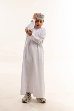 طفل عماني بالدشداشة بتعبيرات وجه قلقة