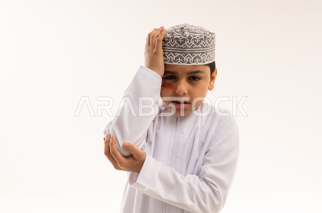 Omani Boy in Dishdasha Expressing Pain on White Background