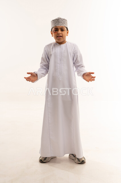 Omani Boy in Traditional Dishdasha and Kumma Hat
