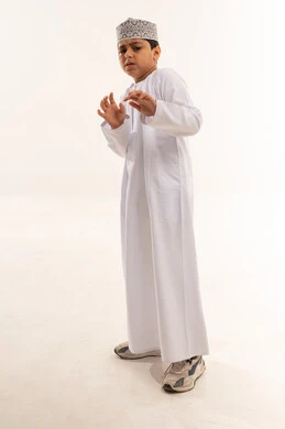 طفل عماني بالزي التقليدي بتعبيرات وجه قلقة