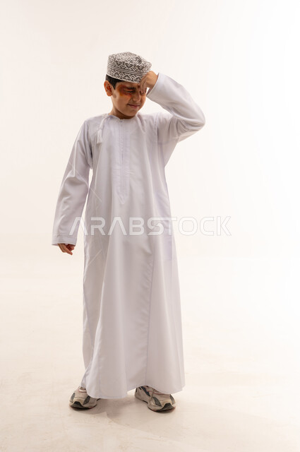 Omani Boy in Traditional Dishdasha with Headache