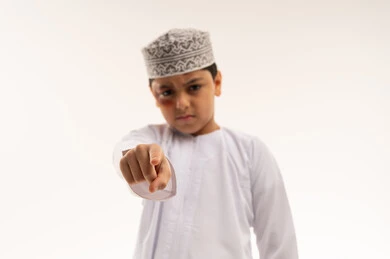 Omani Boy Pointing at Camera with Bruised Face