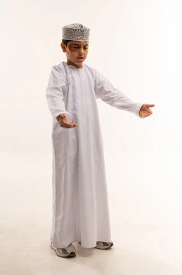 طفل عماني بالدشداشة والكمة العمانية التقليدية