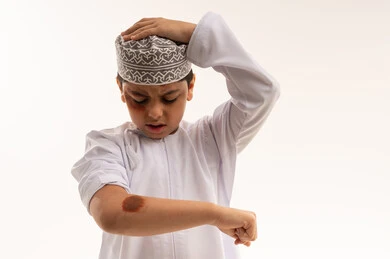 طفل عماني مصاب بكدمات يرتدي الملابس التقليدية