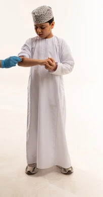 طفل عماني يتلقى الإسعافات الأولية لجرح في ذراعه