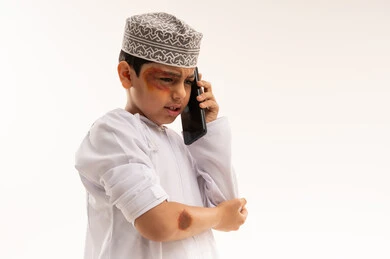 Injured Omani Boy Talking on Smartphone