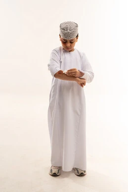Omani Boy in Traditional Dishdasha on White Background