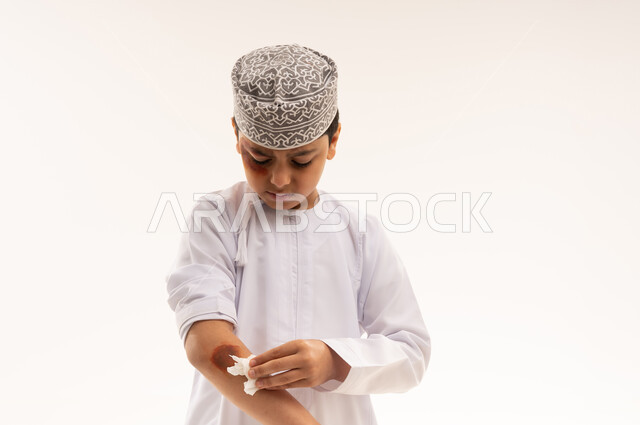 Omani Boy Cleaning Arm Injury on White Background
