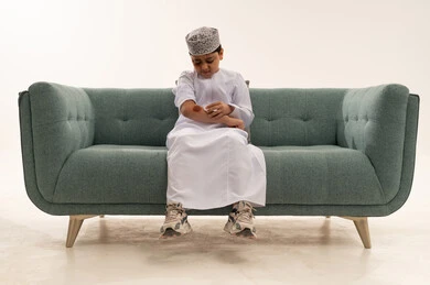 Omani Boy Cleaning Arm Wound on Sofa in Studio