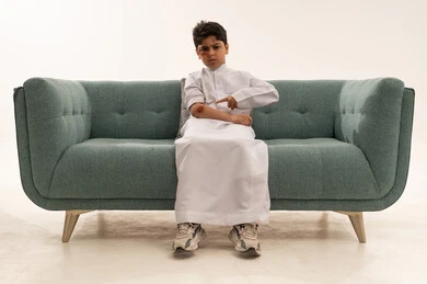 طفل سعودي مصاب يشير إلى كدمة في الاستوديو