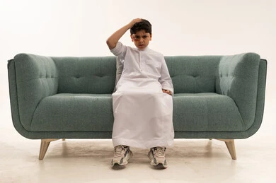 Injured Saudi Boy with Bruised Eye on Sofa