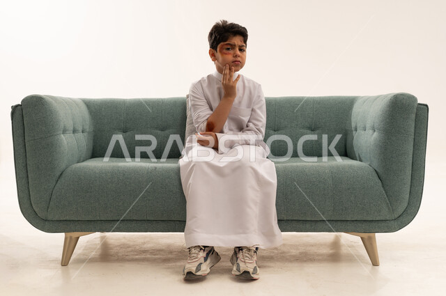 Injured Saudi Boy with Facial Bruising on Sofa