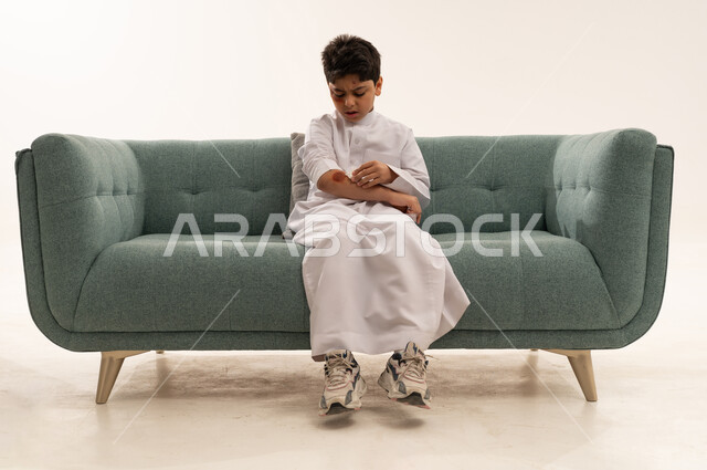 طفل سعودي بالثوب ينظف جرحا في ذراعه