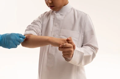 طفل سعودي يتلقى الإسعافات الأولية لإصابة في الكوع