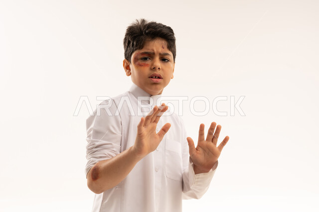 Injured Saudi Boy with Bruised Face in Defensive Pose