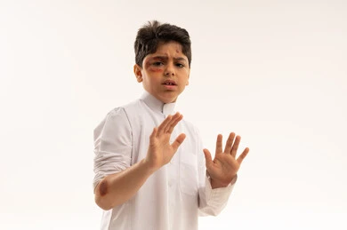 طفل سعودي مصاب بكدمات في وضعية دفاعية