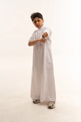 طفل سعودي بالثوب الأبيض يشير بتعبيرات غاضبة