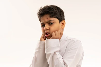 طفل عربي بالثوب الأبيض مع كدمات في الوجه