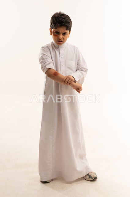 Angry Saudi Boy in White Thobe with Arm Bruise