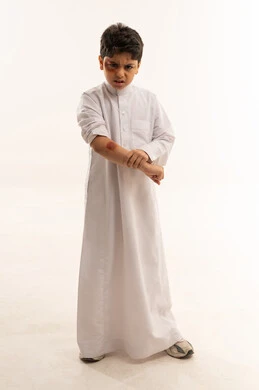 طفل سعودي بالثوب الأبيض مع كدمة على الذراع