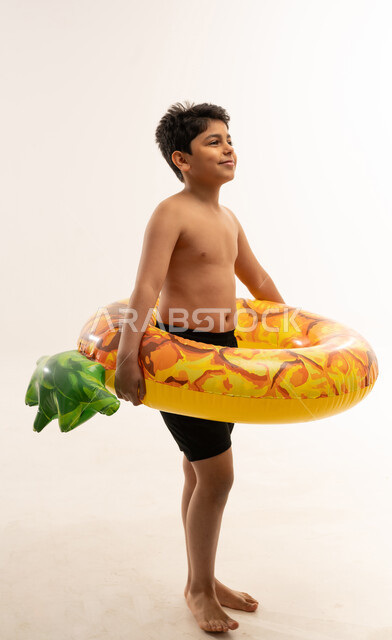 Arab Boy with Pineapple Swim Ring on White Background