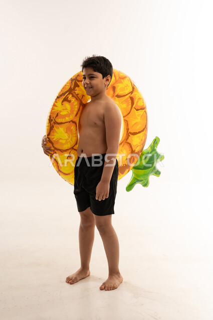 Arab Boy with Pineapple Inflatable Ring in Studio
