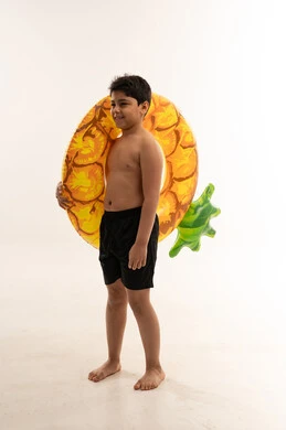 طفل عربي مع طوق نجاة أناناس في استوديو