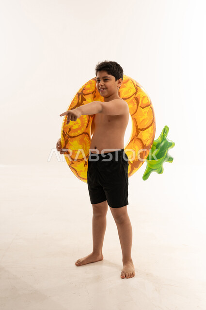 Saudi Boy Holding Pineapple Swim Ring on White Background